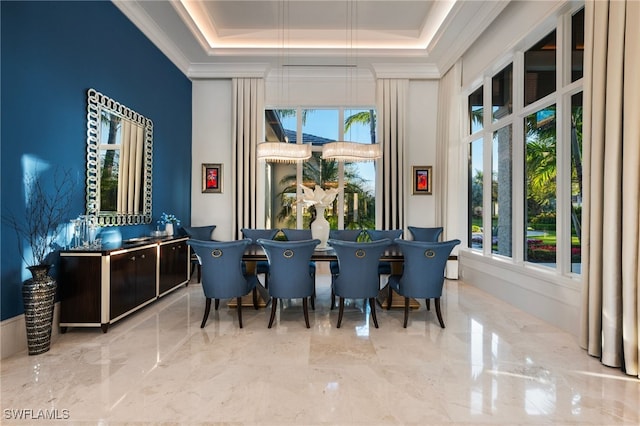 dining area featuring a tray ceiling, marble finish floor, and crown molding