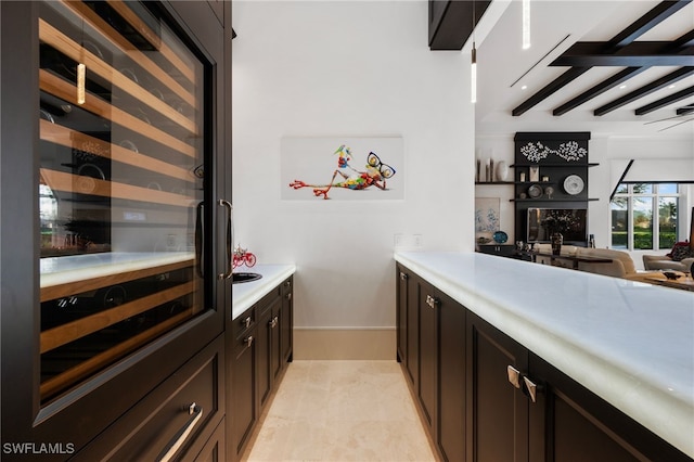 bar with wine cooler, beam ceiling, and baseboards