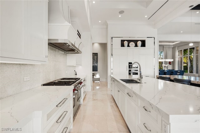 kitchen featuring range with two ovens, a sink, custom exhaust hood, light stone countertops, and crown molding