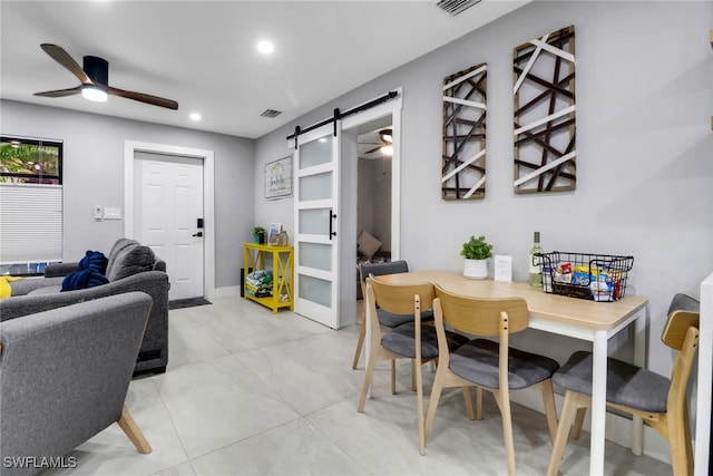 dining area featuring a barn door, ceiling fan, and recessed lighting