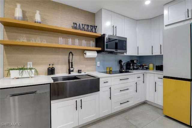 kitchen with decorative backsplash, stainless steel appliances, light countertops, white cabinetry, and open shelves