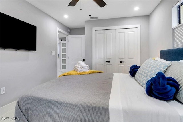 bedroom with recessed lighting, a closet, visible vents, and a barn door