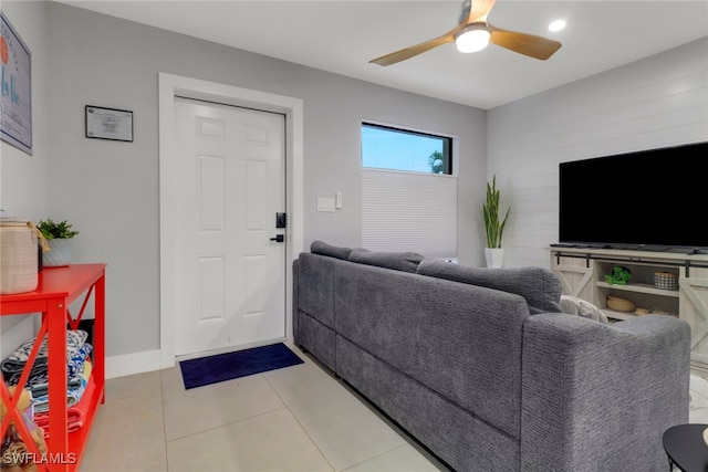 living room featuring light tile patterned floors, a ceiling fan, and baseboards