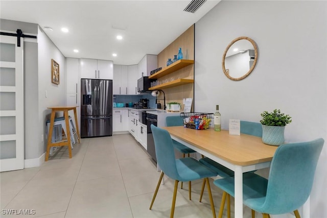 kitchen featuring a barn door, visible vents, stainless steel fridge with ice dispenser, white cabinetry, and open shelves