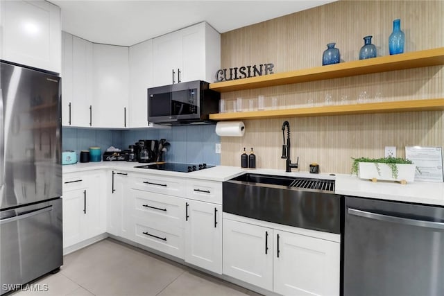 kitchen featuring stainless steel appliances, white cabinets, light countertops, open shelves, and tasteful backsplash