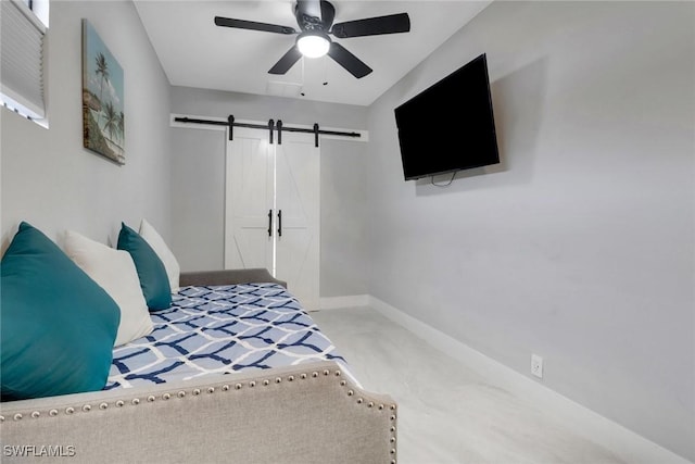 bedroom with a barn door, baseboards, and ceiling fan