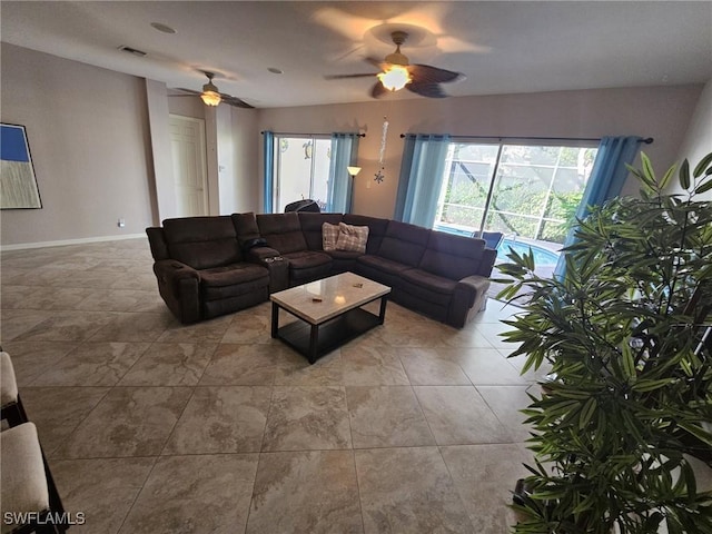 living room with a healthy amount of sunlight, baseboards, visible vents, and a ceiling fan