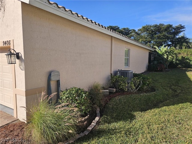 view of property exterior featuring a garage, a yard, and stucco siding