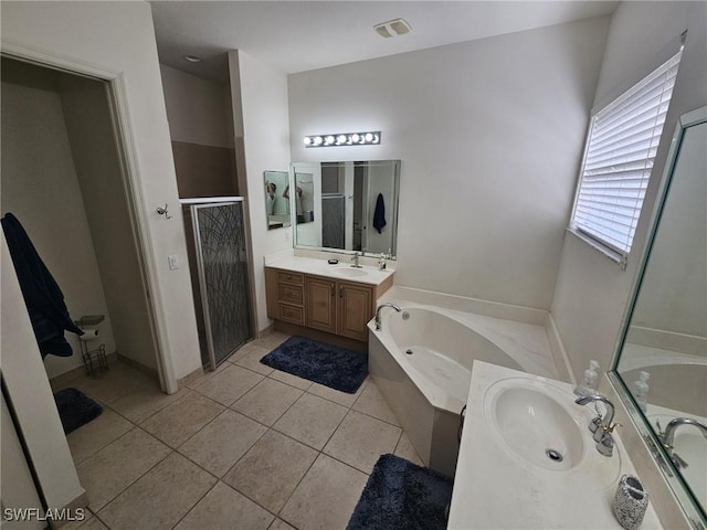 full bathroom featuring a garden tub, two vanities, a sink, a shower stall, and tile patterned flooring