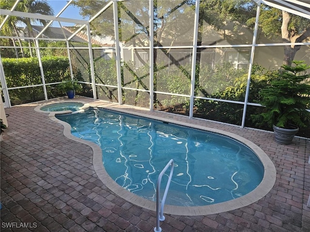 view of swimming pool with a patio, a pool with connected hot tub, and glass enclosure