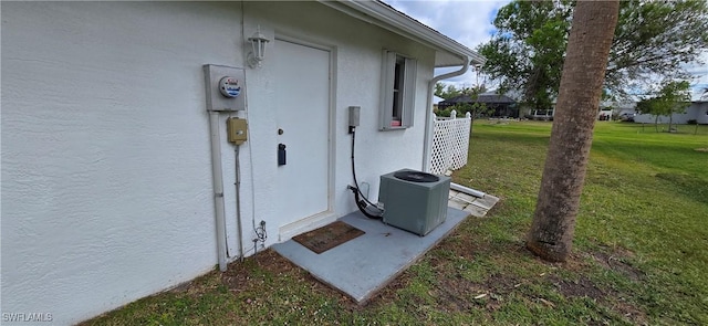 details featuring electric meter, cooling unit, and stucco siding