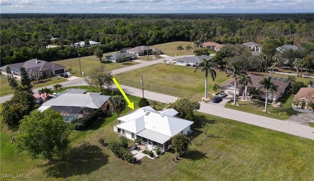 drone / aerial view featuring a residential view and a wooded view