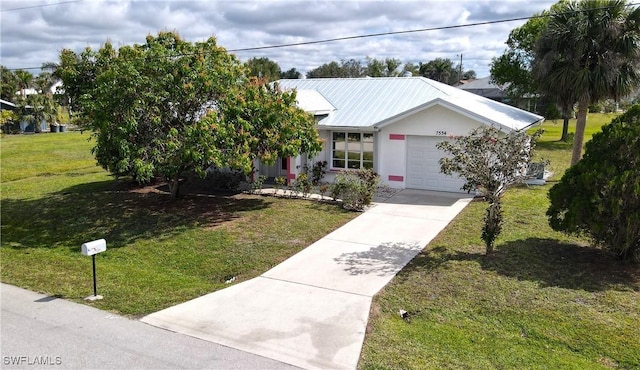 view of front facade with metal roof, an attached garage, concrete driveway, stucco siding, and a front lawn