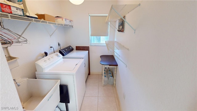 laundry area with light tile patterned floors, laundry area, a sink, and washer and dryer