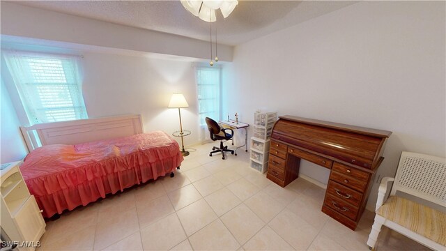 bedroom featuring light tile patterned floors and a textured ceiling