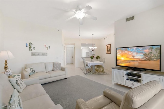 living area with ceiling fan with notable chandelier and visible vents