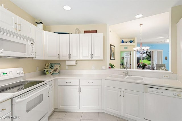 kitchen featuring a chandelier, white appliances, white cabinets, and a sink