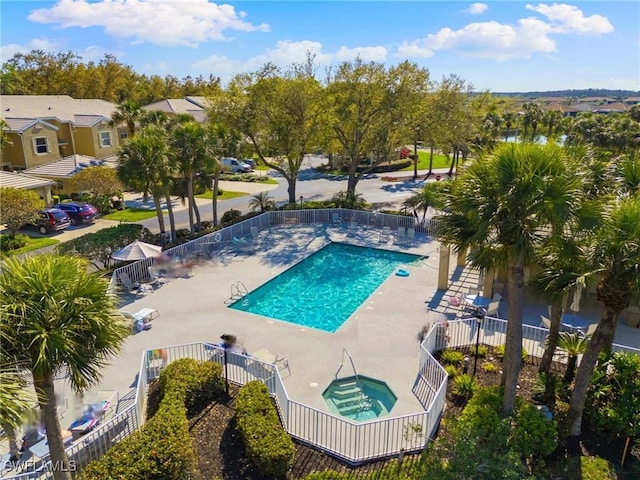 pool with a patio area, fence, and a community hot tub