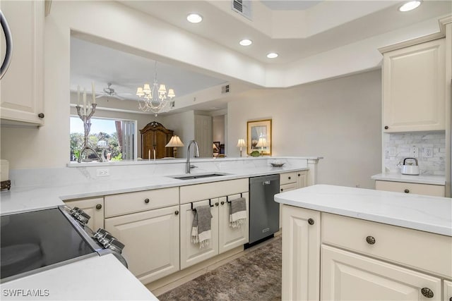 kitchen with a sink, visible vents, decorative backsplash, dishwasher, and a tray ceiling