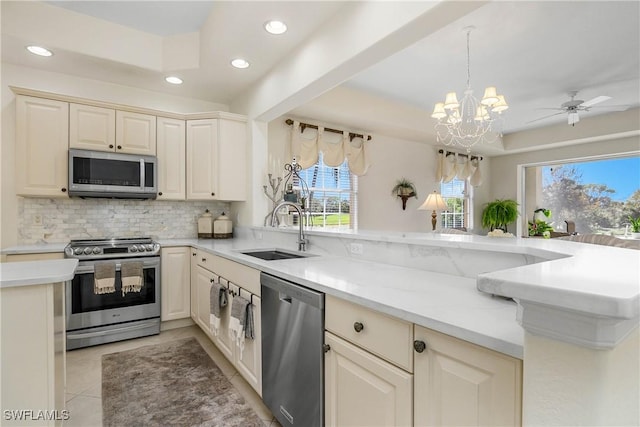 kitchen with light tile patterned floors, recessed lighting, a sink, appliances with stainless steel finishes, and decorative backsplash