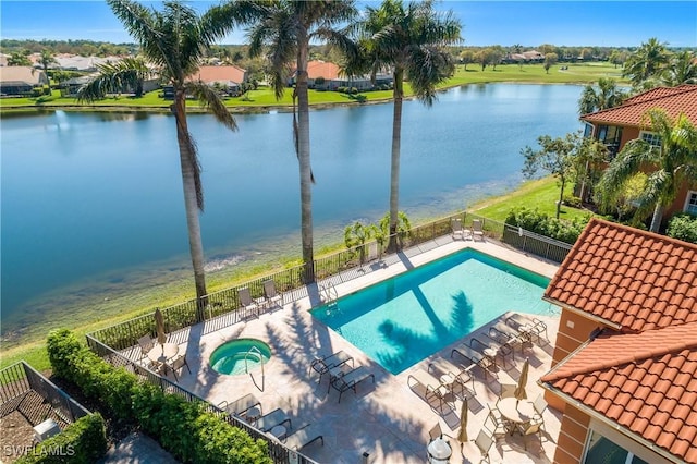 pool featuring a water view, a patio, a hot tub, and fence