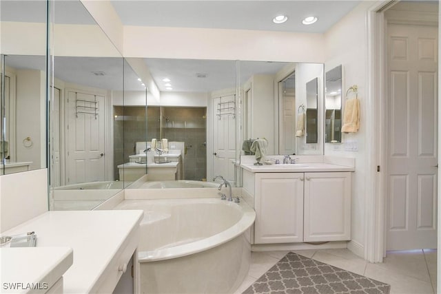 full bathroom featuring tile patterned flooring, a garden tub, a sink, two vanities, and a stall shower