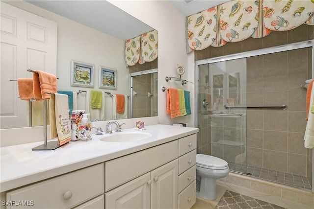 bathroom with vanity, a shower stall, toilet, and tile patterned floors