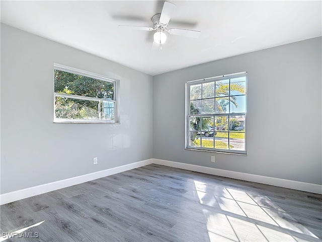 spare room with a ceiling fan, baseboards, and wood finished floors