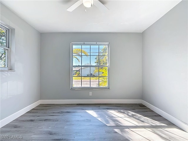 unfurnished room with a ceiling fan, baseboards, and wood finished floors