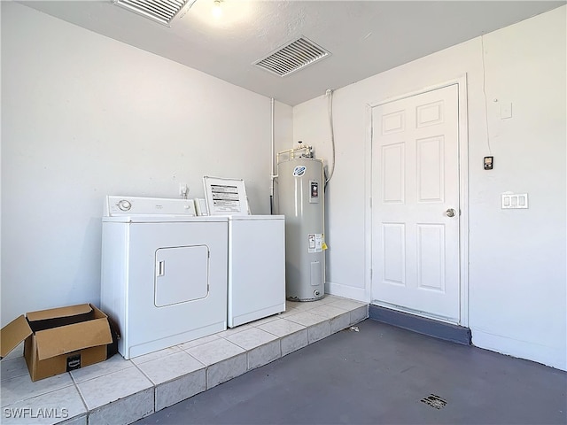 clothes washing area with water heater, washer and clothes dryer, and visible vents