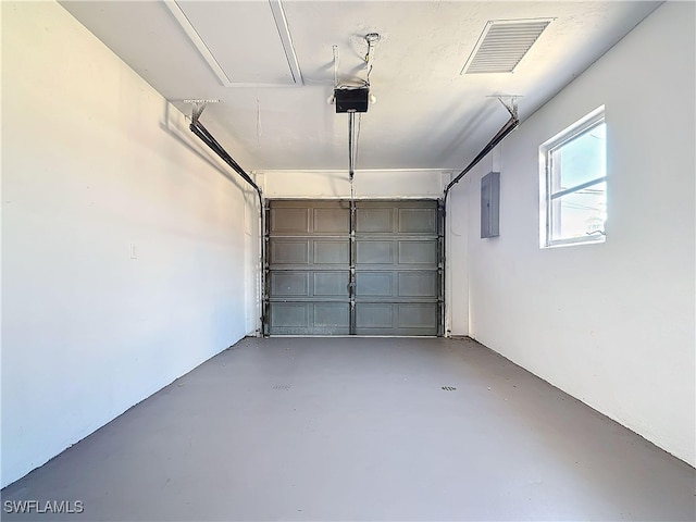 garage with electric panel, visible vents, and a garage door opener