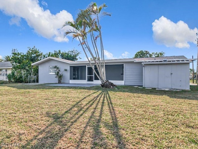 back of property featuring a sunroom, a patio area, and a lawn