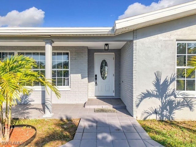 doorway to property with brick siding