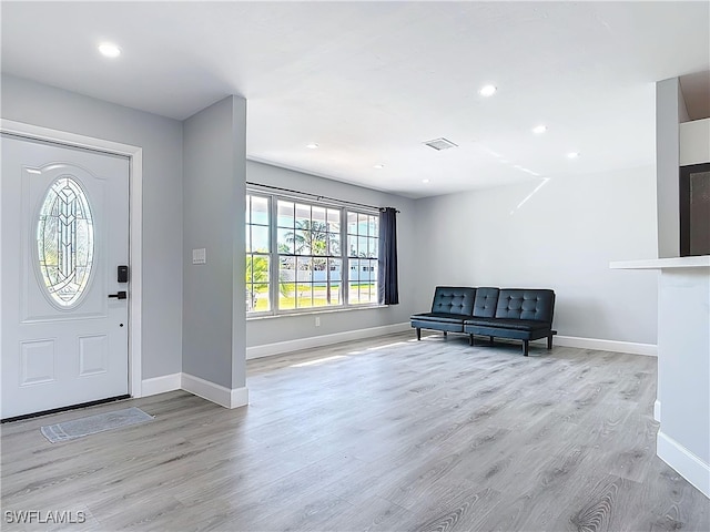 foyer featuring baseboards, visible vents, wood finished floors, and recessed lighting