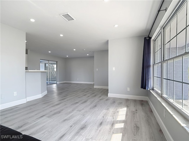 unfurnished room featuring recessed lighting, visible vents, light wood-style flooring, and baseboards