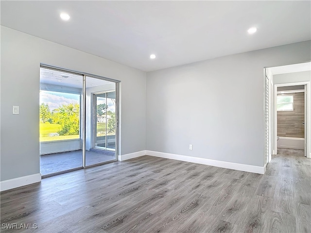 empty room with baseboards, recessed lighting, and light wood-style floors