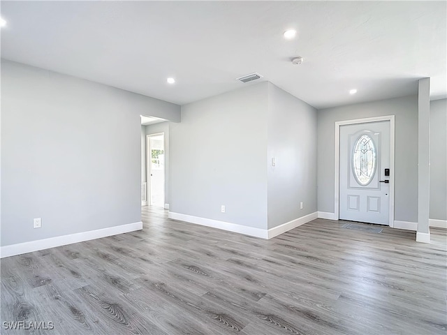 foyer entrance featuring light wood-style flooring, visible vents, and baseboards