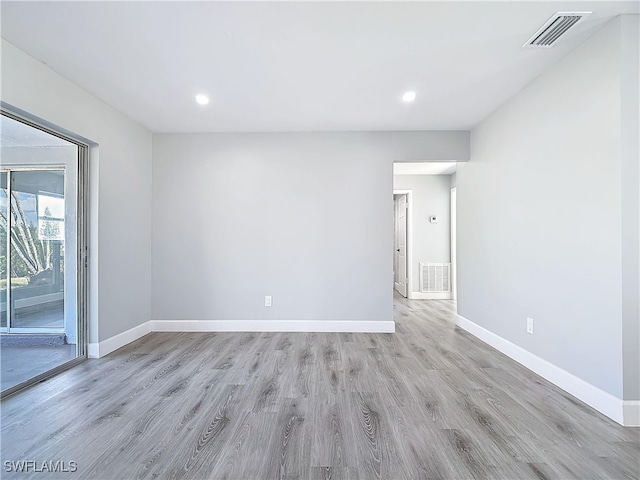 spare room with baseboards, visible vents, light wood-style flooring, and recessed lighting