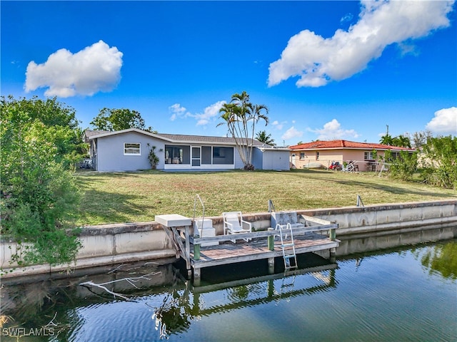 rear view of property with a water view and a yard