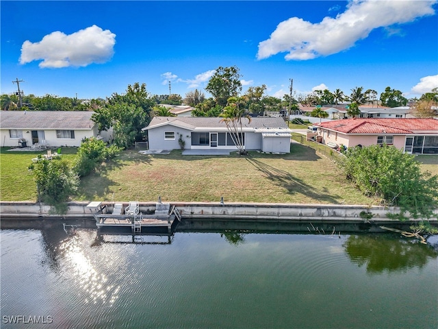 back of property with a water view and a lawn