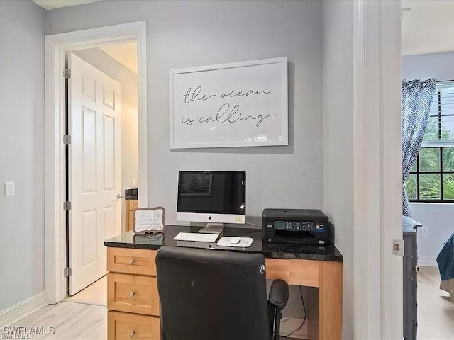 home office with light wood finished floors and baseboards