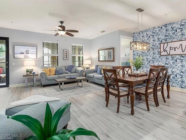 dining area featuring baseboards, an accent wall, light wood-style flooring, and wallpapered walls