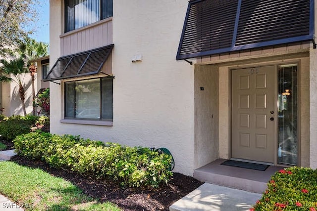 entrance to property featuring stucco siding