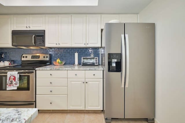 kitchen featuring stainless steel appliances, white cabinetry, light stone counters, and decorative backsplash