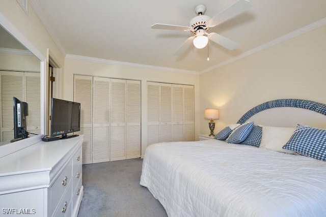 carpeted bedroom with a ceiling fan, crown molding, and two closets