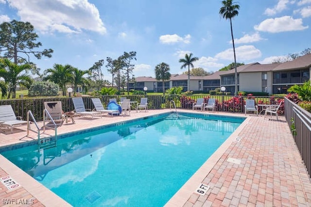 community pool featuring a patio area and fence