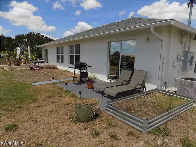 back of property featuring a patio area, central AC, roof with shingles, and stucco siding