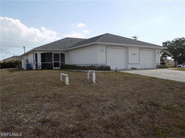 view of home's exterior featuring roof with shingles, a yard, stucco siding, a garage, and driveway