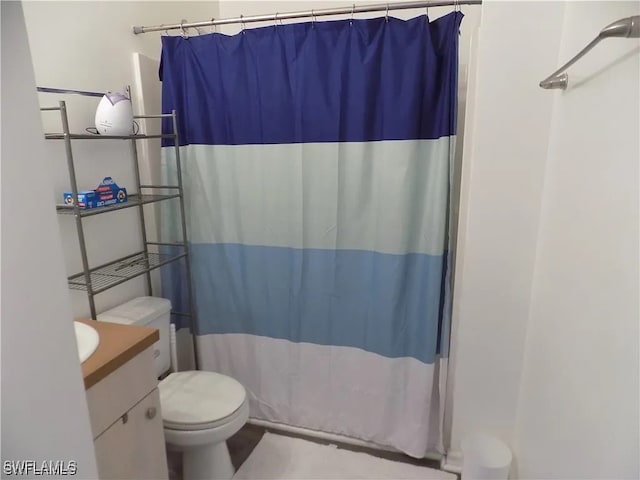 full bath with a shower with curtain, vanity, and toilet