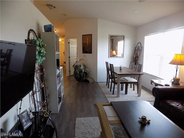 dining space featuring vaulted ceiling and wood finished floors